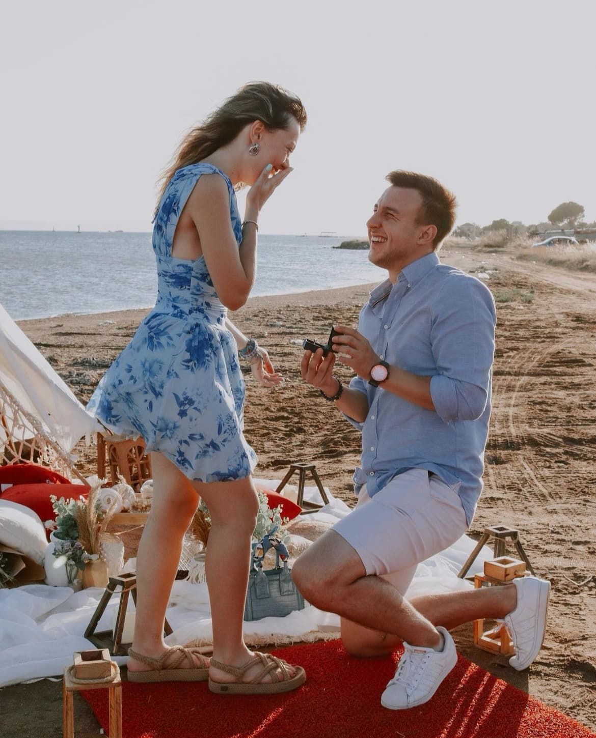 Genç bir erkeğin plajda genç bir kadına evlenme teklif ediyor.