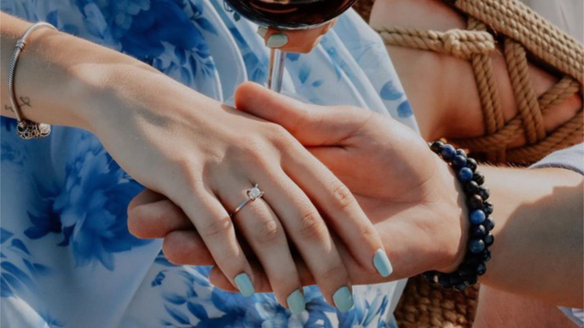 Şarap içerken romantik bir şekilde el ele tutuşan çift.